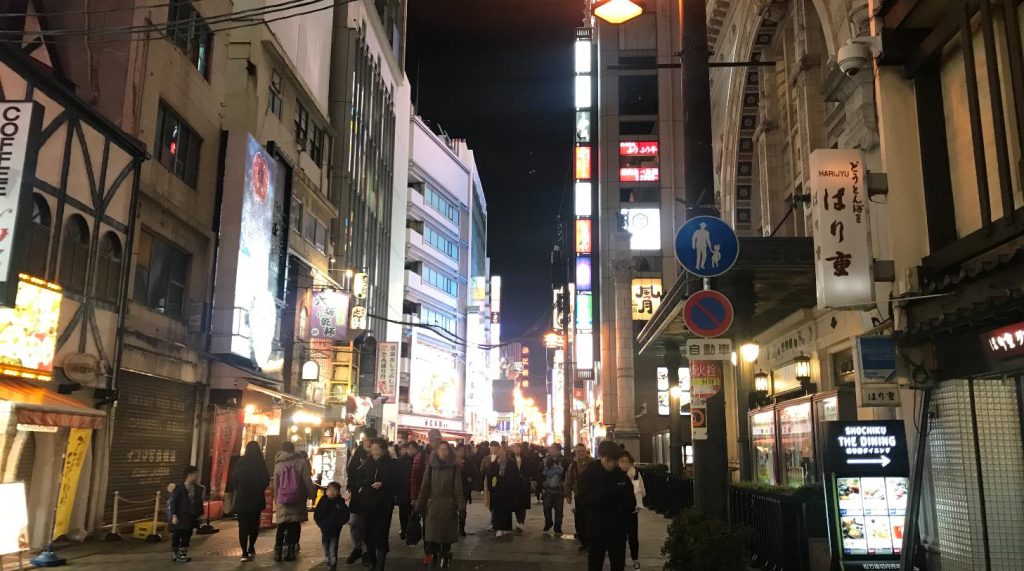 Evening crowds walking beside illuminated signs in Dotonbori, Osaka